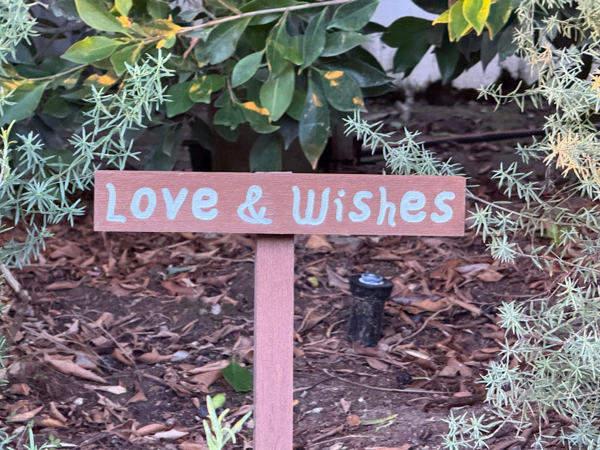 Wooden sign with love & wishes written on it.