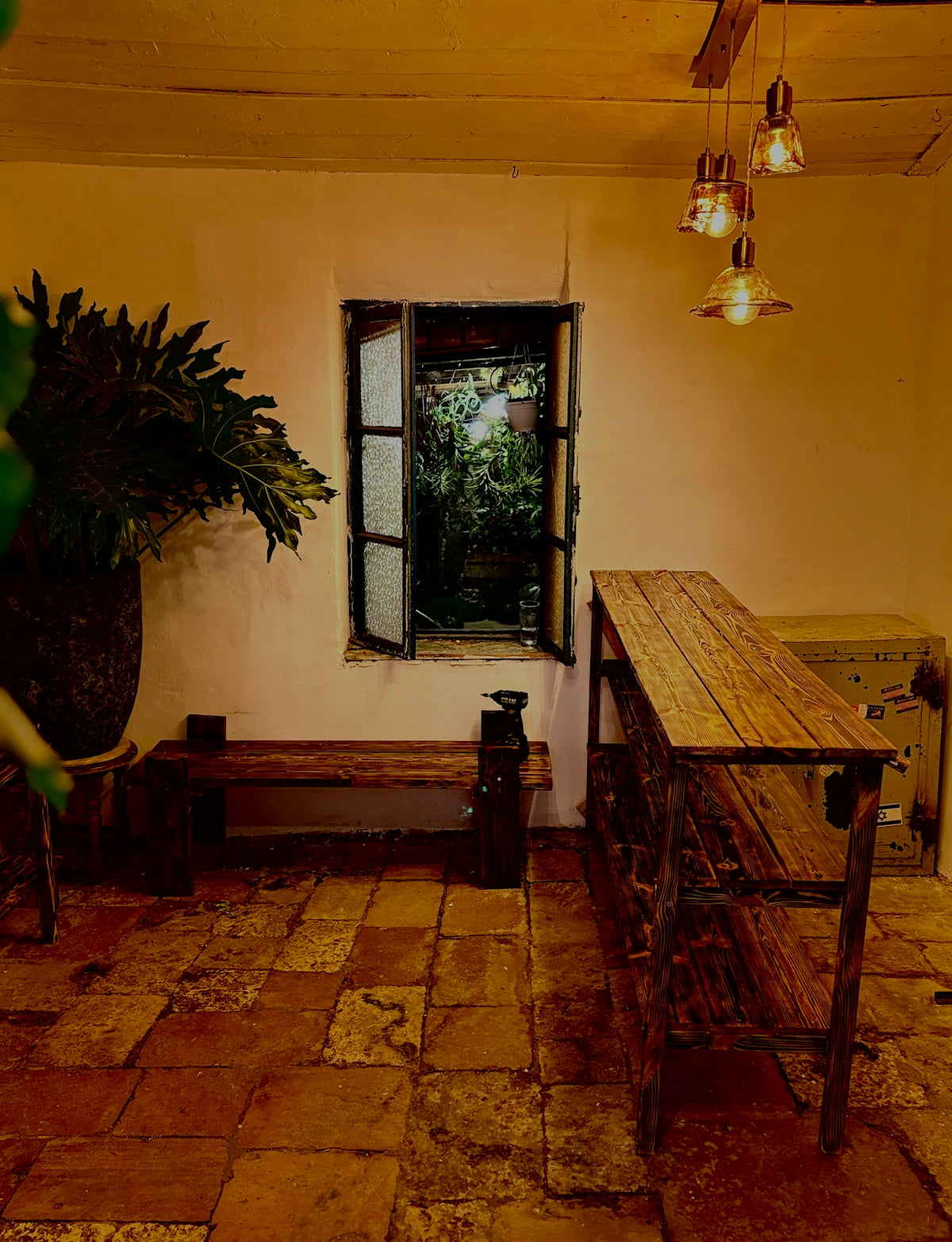 Interior room with open window revealing lush greenery.
