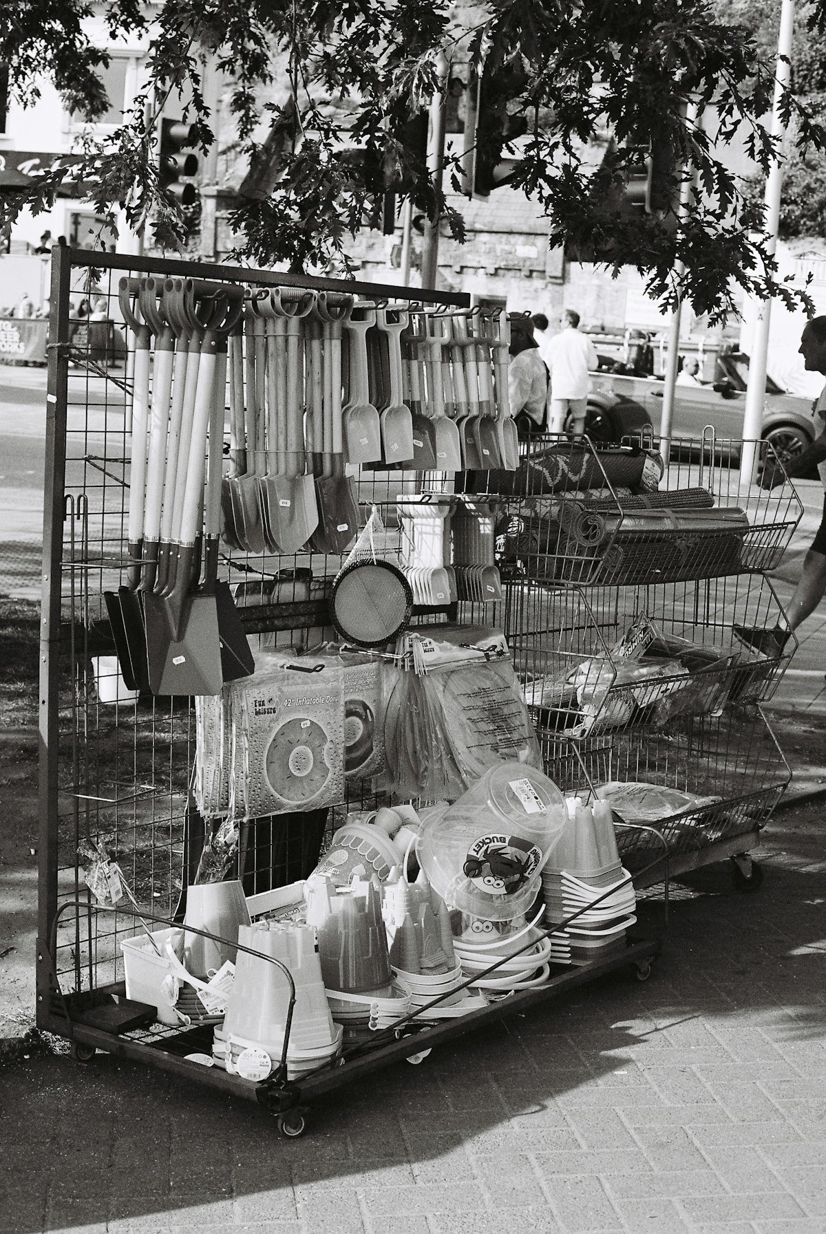 Gardening tools and household items displayed on a street cart.