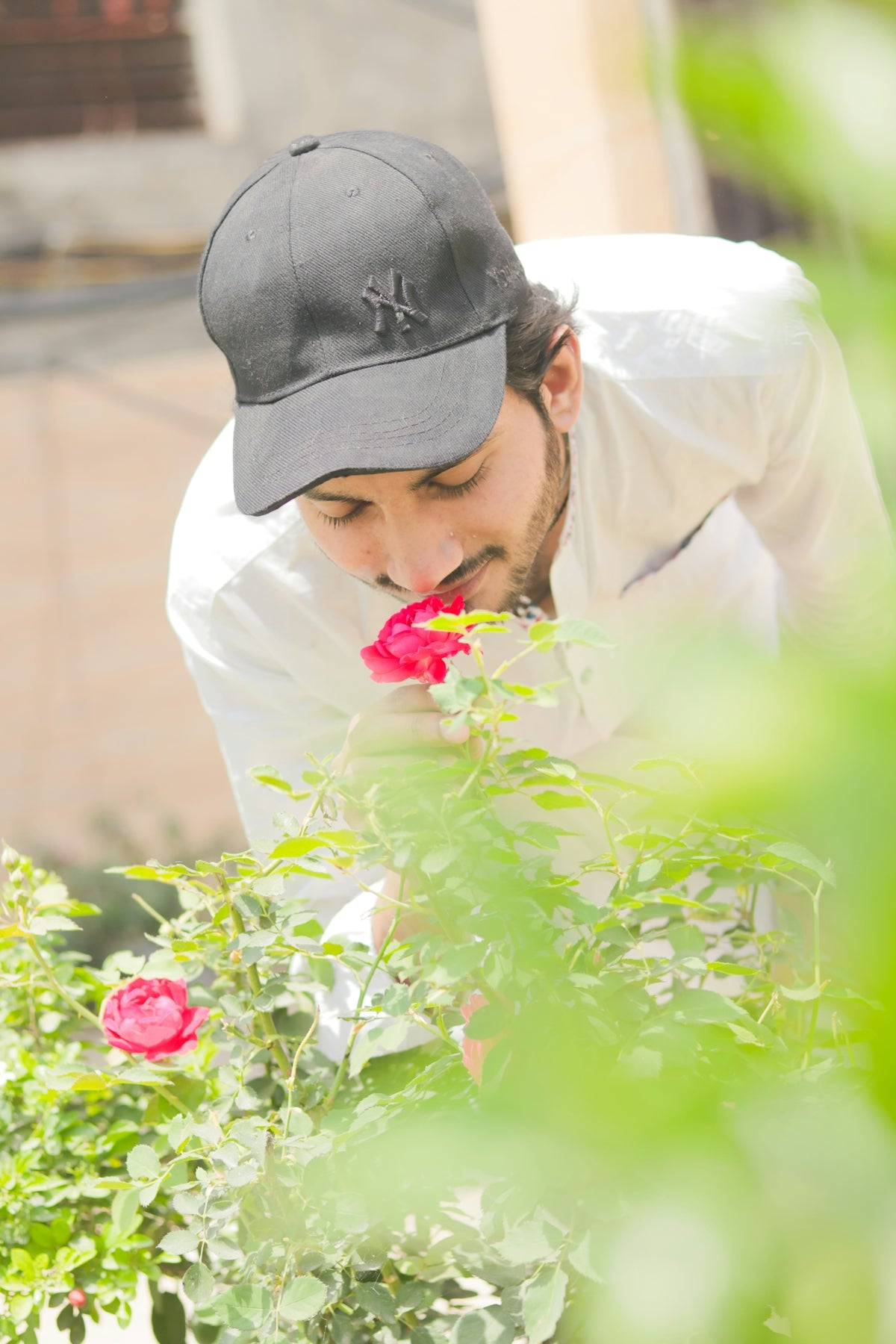 a man smelling a flower in a garden