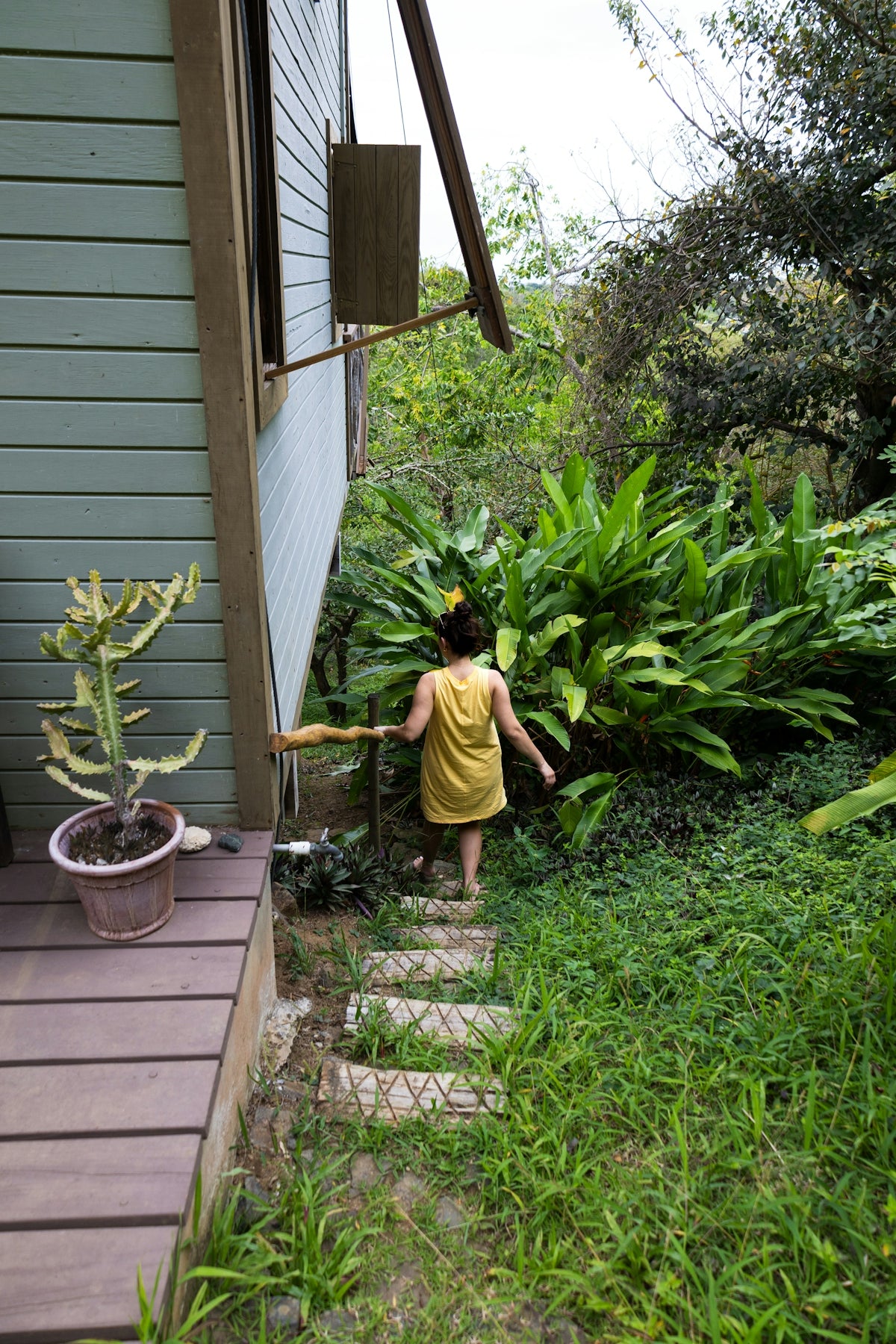 A woman walks down steps to the garden.