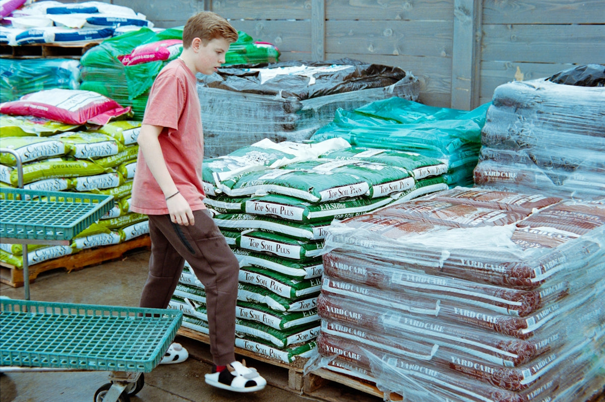 Young boy walks past stacks of bagged goods